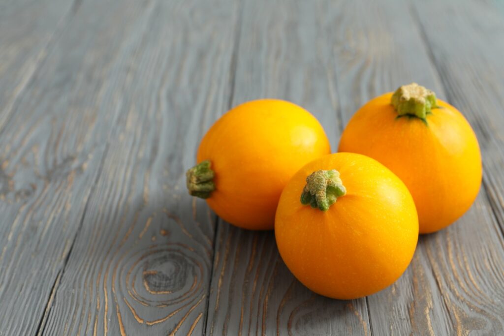 Des courgettes oranges sur une table en bois