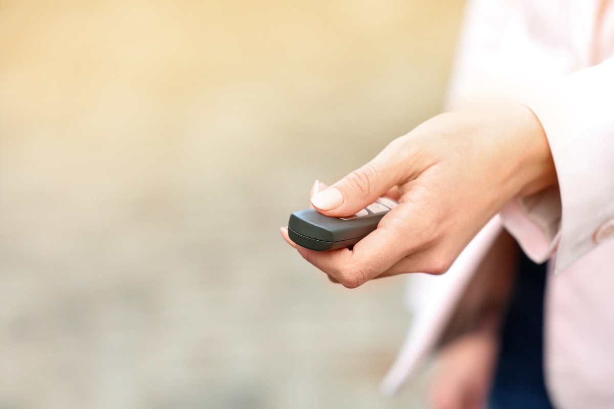 Une femme ouvrant un portail avec une télécommande