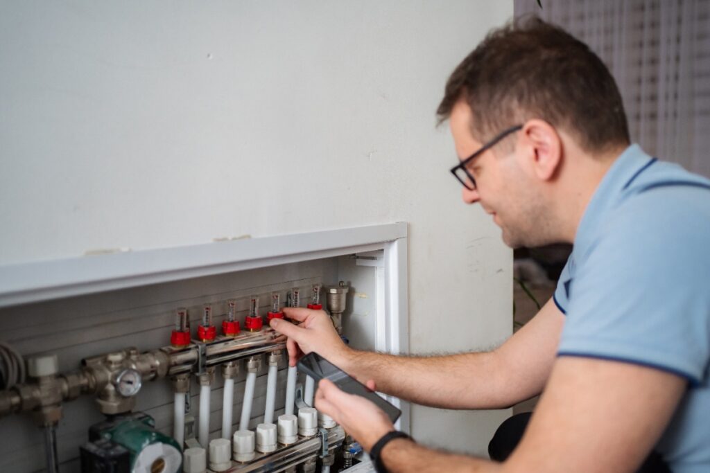 Un homme inspectant le collecteur de chauffage