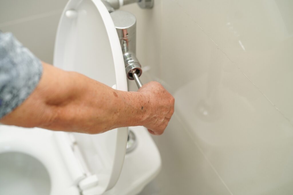 Main faisant un réglage de la chasse d'eau