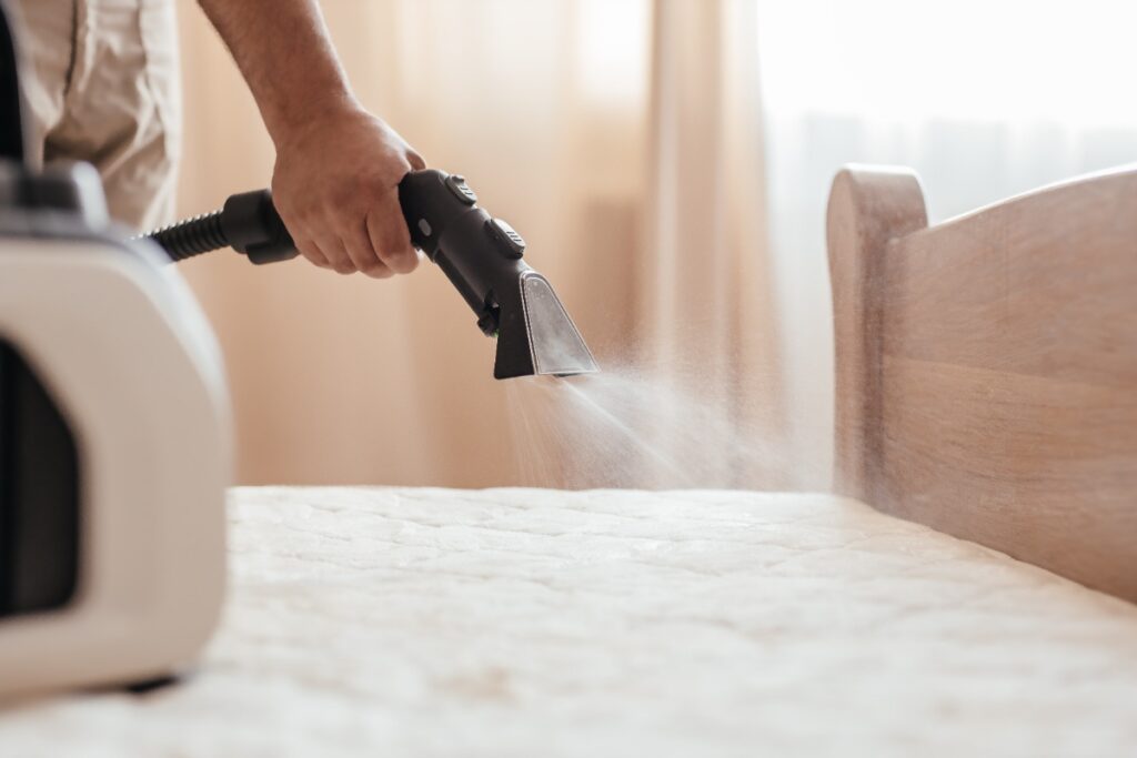 Une personne nettoyant le matelas en profondeur