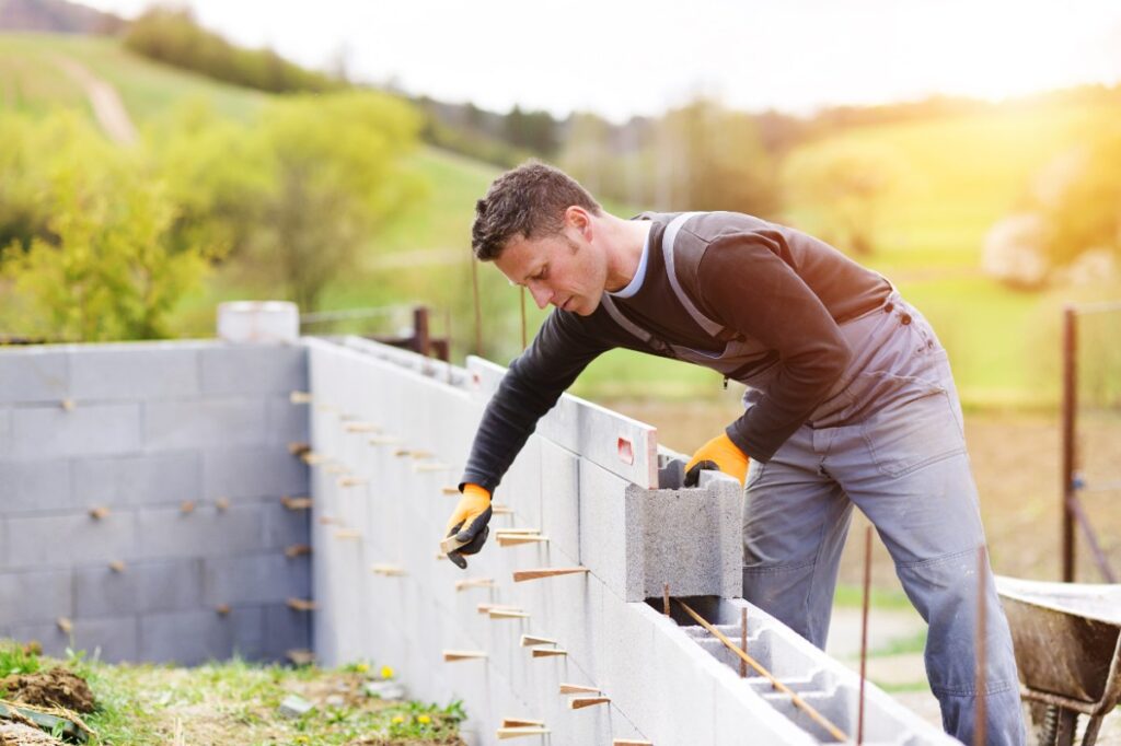 Un homme qui construit une maison en parpaings