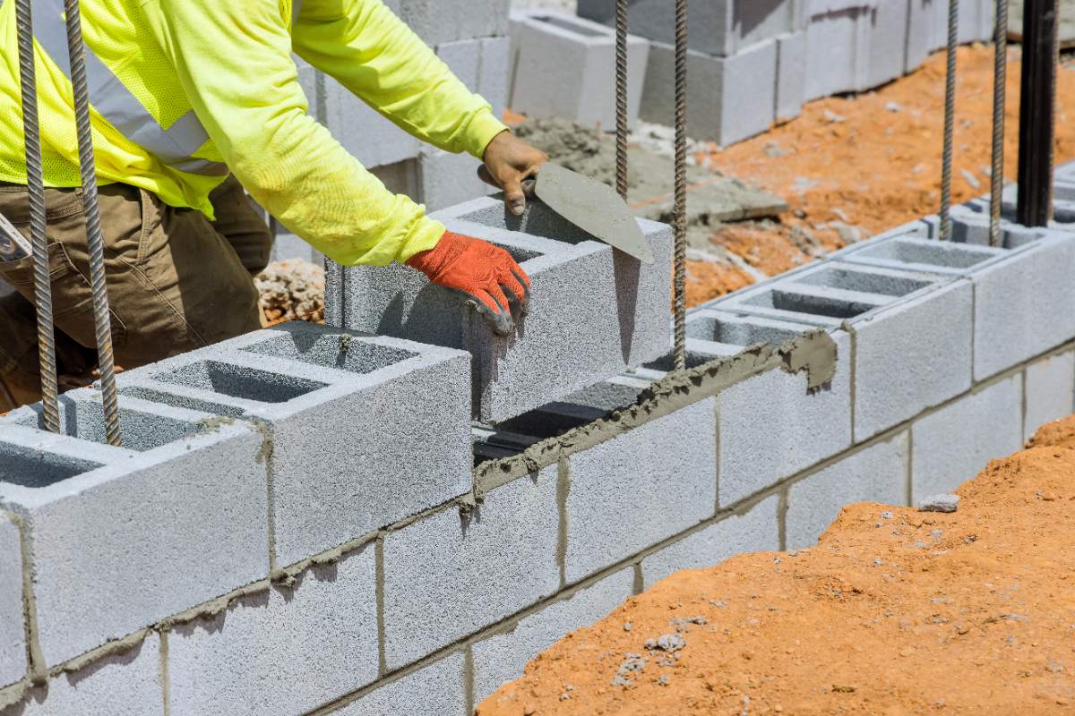 Un homme qui construit un mur en parpaings