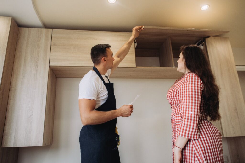 Un homme et une femme qui discutent de l'installation des meubles dans une cuisine