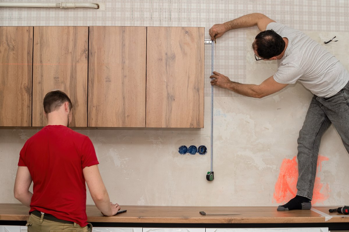Des hommes installant des armoires de cuisine