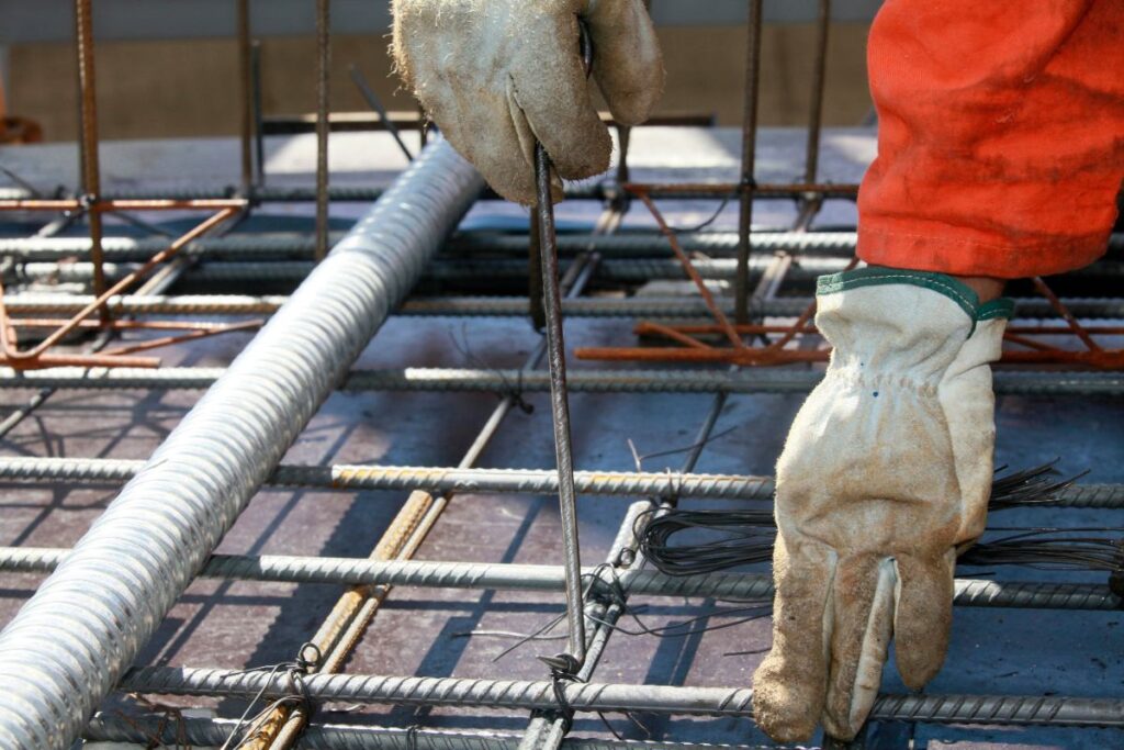 Un ouvrier de bâtiment fixant les barres d'armatures sur un chantier