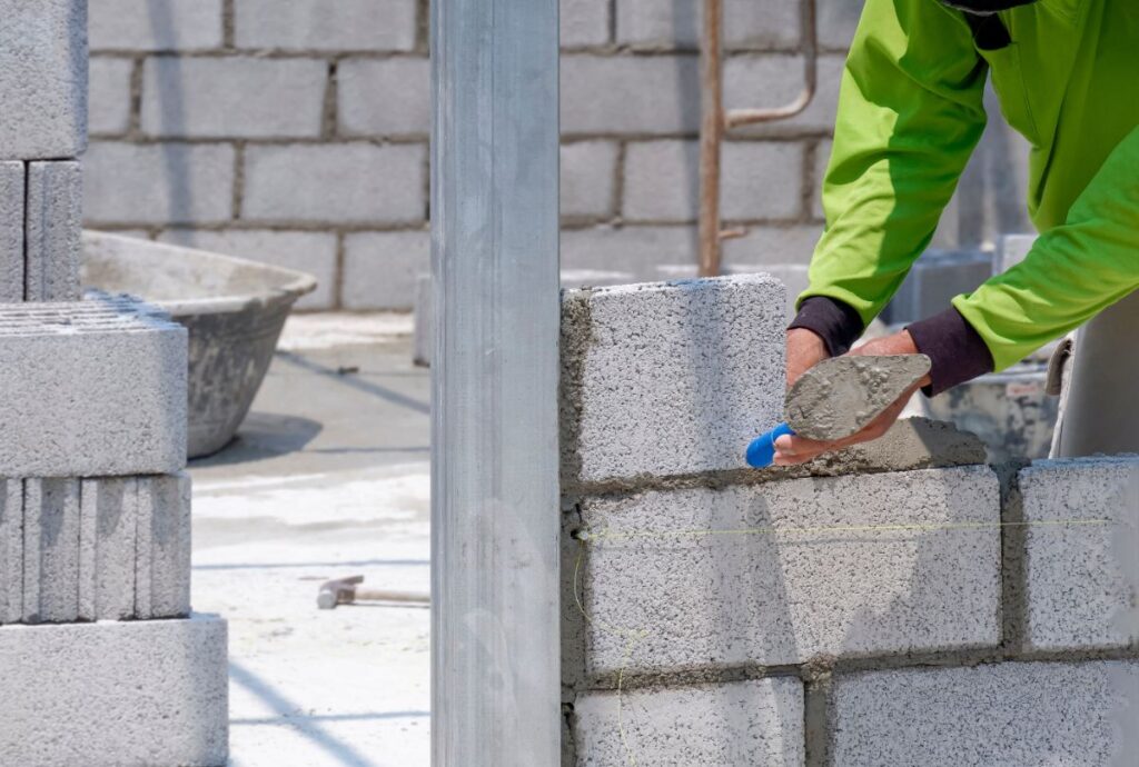 Un ouvrier construisant un mur en parpaings