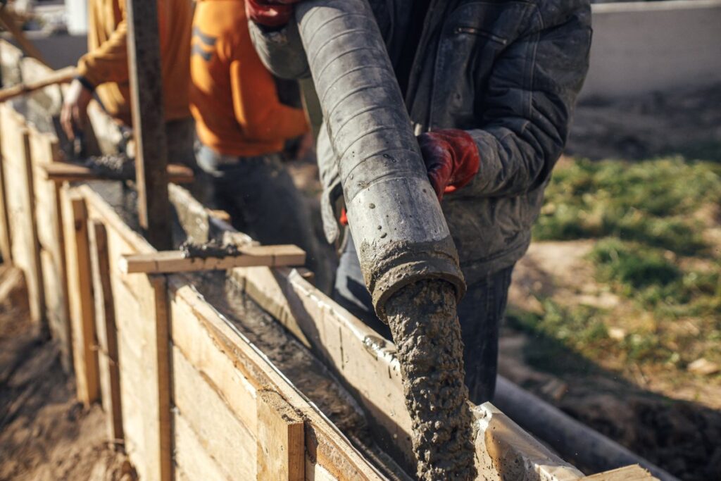 Un ouvrier coulant du béton sur un chantier