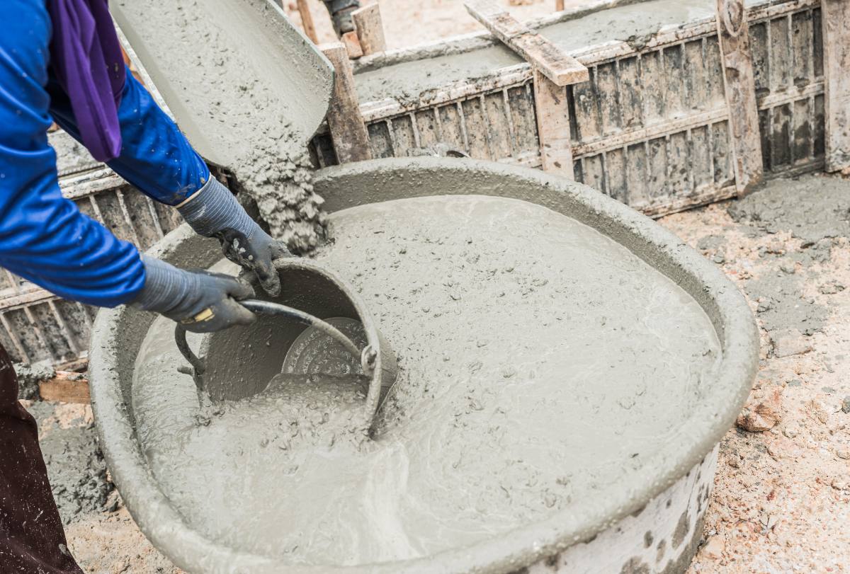 Un ouvrier prenant du béton avec un seau